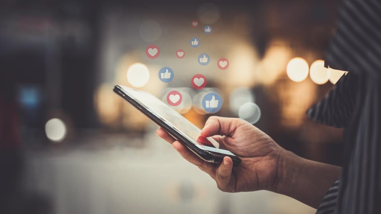 Une personne utilisant Facebook sur son téléphone intelligent.
