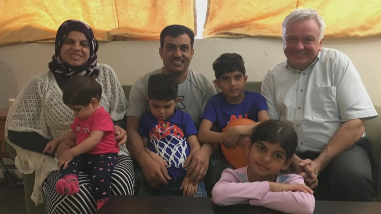 Une famille de réfugiés syriens et un bénévole canadien posent pour une photo. Une famille de réfugiés syriens et un bénévole canadien posent pour une photo.