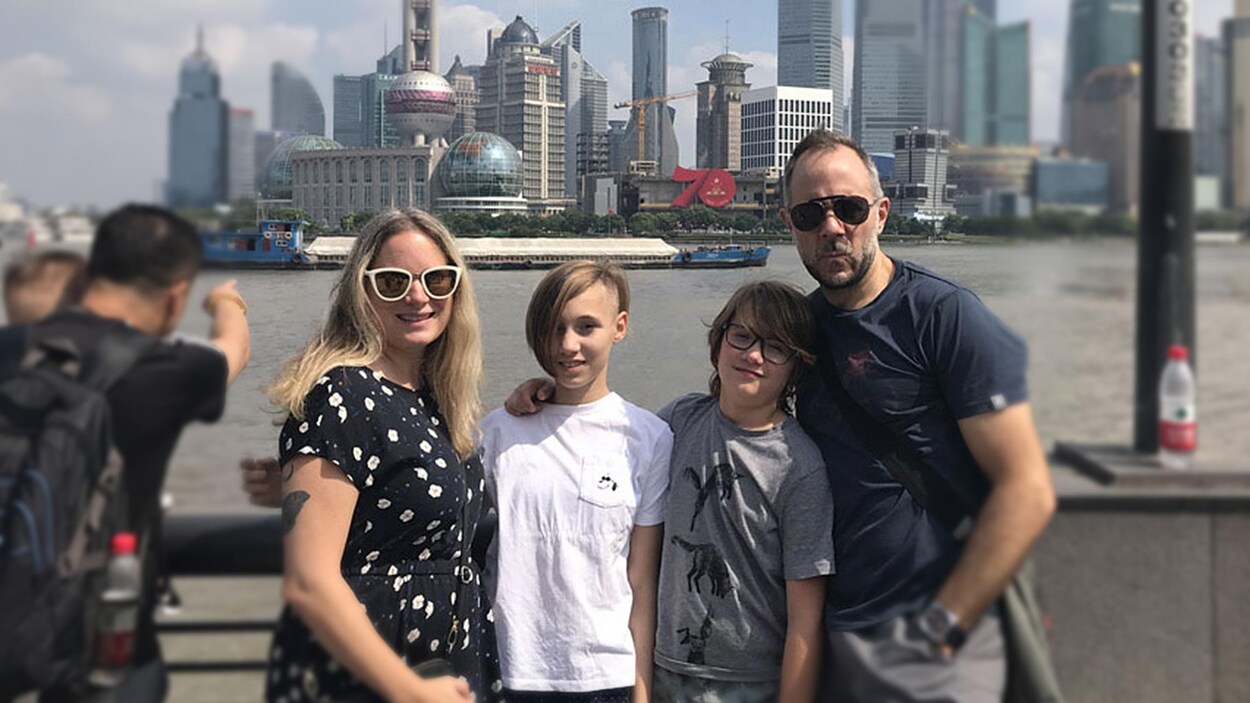 Une femme et un homme avec leurs deux enfants devant la ville de Shanghai.