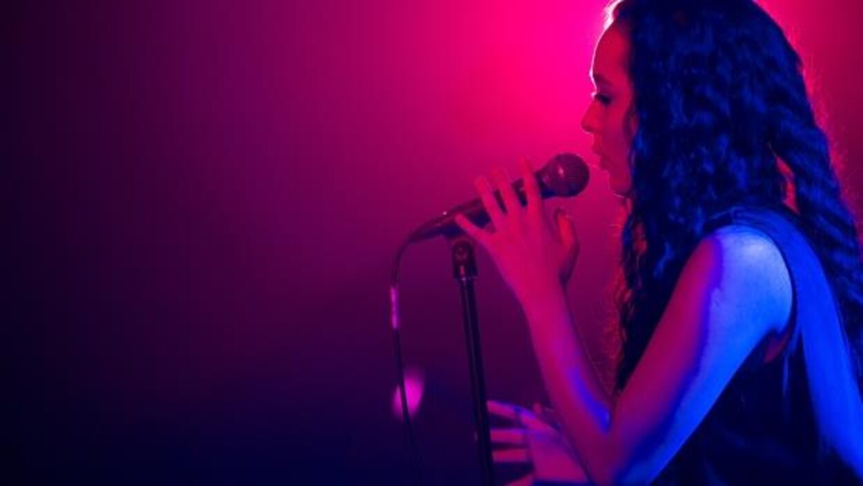 Faouzia qui chante sur fond rose Faouzia qui chante sur fond rose