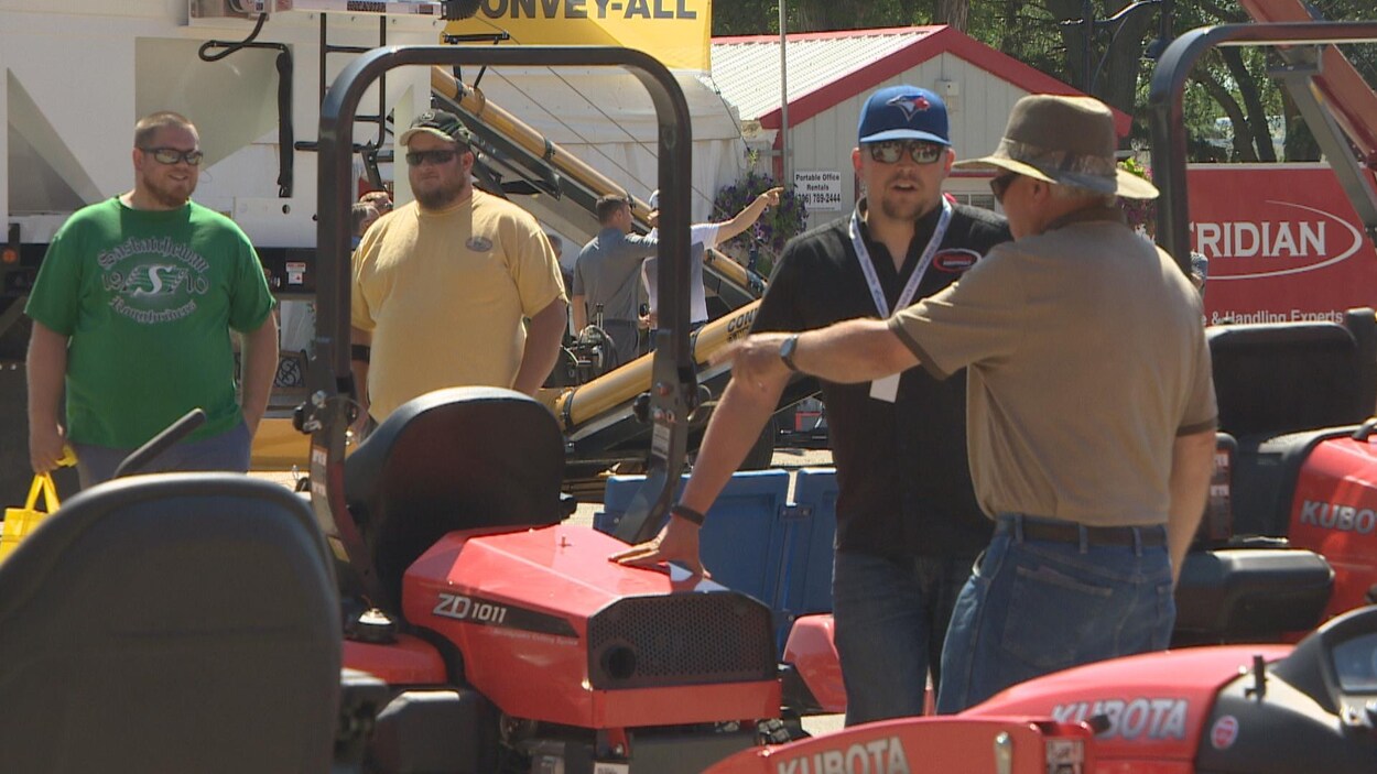 Deux personnes qui discutent lors de l'exposition Farm Progress Show. Deux personnes qui discutent lors de l'exposition Farm Progress Show.