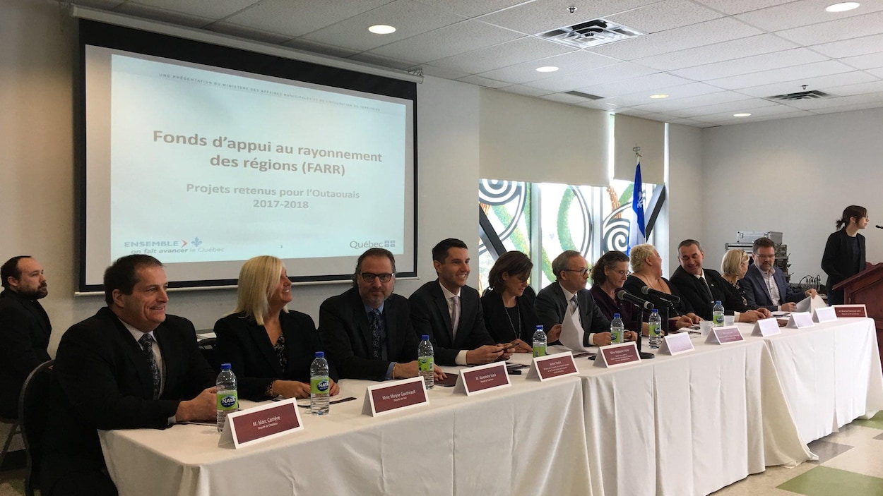 Les cinq députés provinciaux de l'Outaouais sont assis à une table avec le ministre Coiteux et des élus municipaux. Les cinq députés provinciaux de l'Outaouais sont assis à une table avec le ministre Coiteux et des élus municipaux.