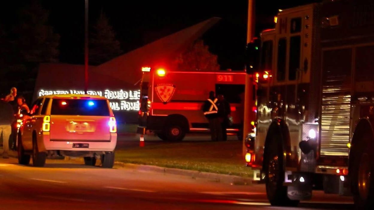 Véhicule de police, ambulance et camion de pompiers près de l'enseigne à l'entrée de l'aéroport.
