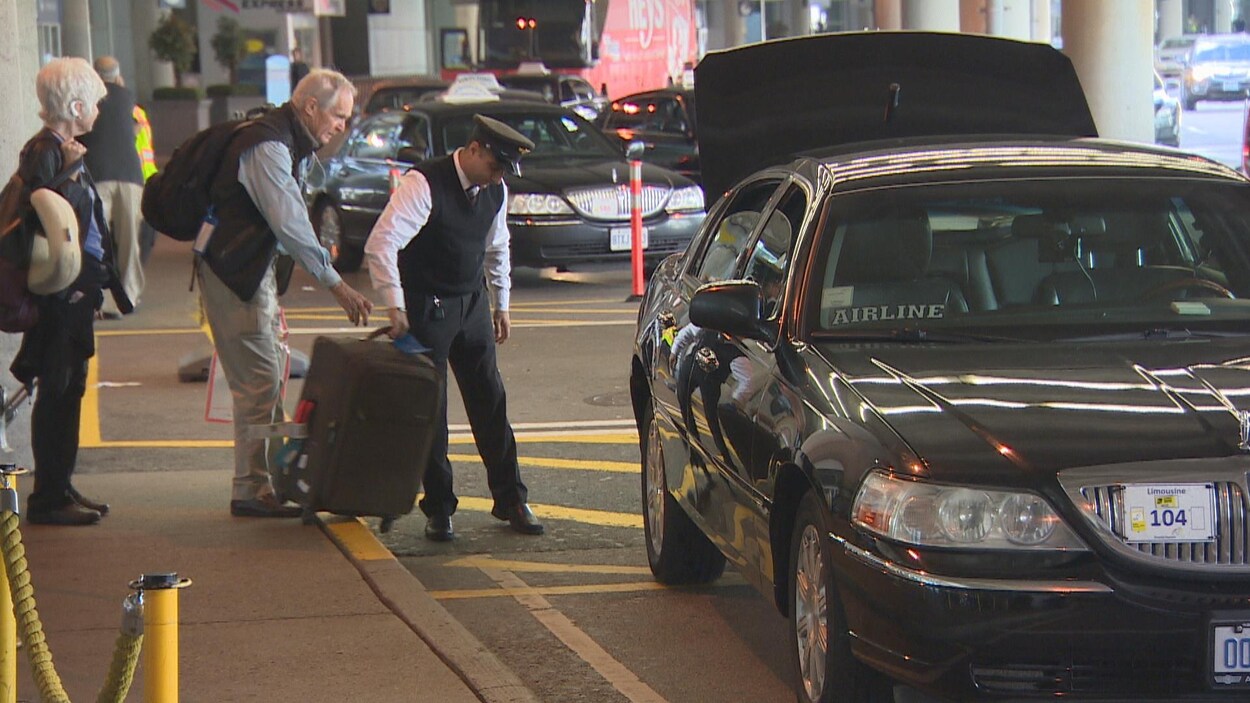 Un couple de voyageurs s'apprête à embarquer dans un taxi.