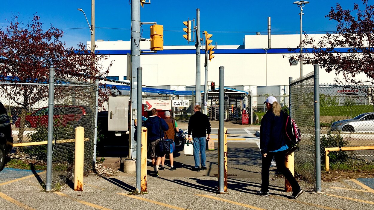 Des travailleurs s'apprêtent à traverser la rue.
