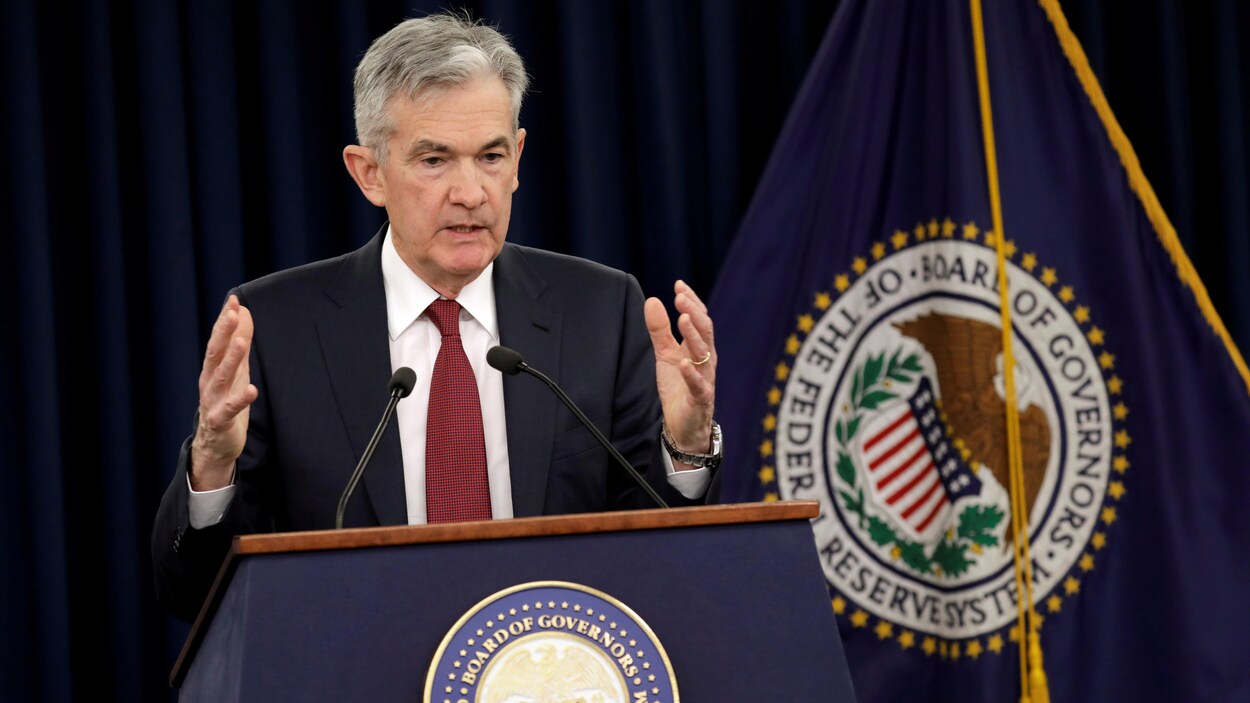 Jerome Powell parle dans un micro, debout devant un lutrin.
