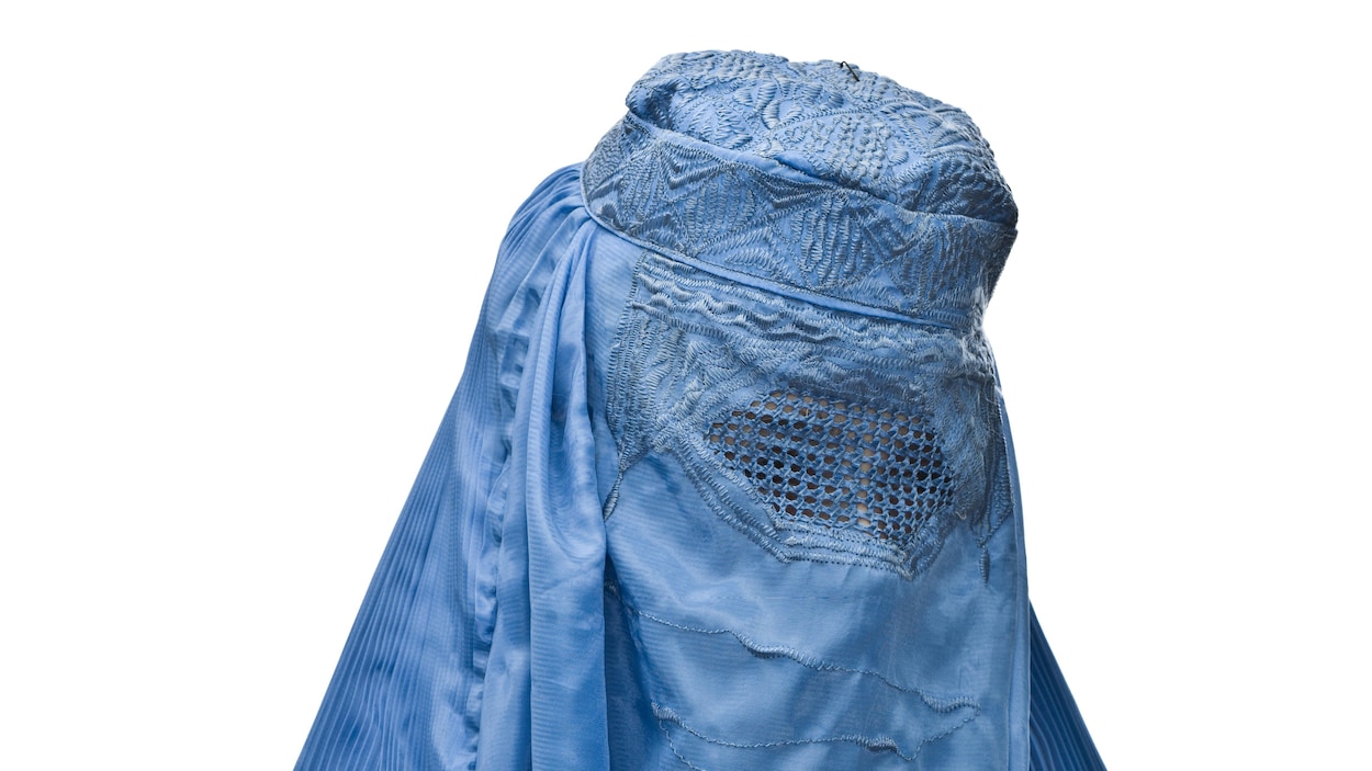 Une femme porte une burqa bleue. Une femme porte une burqa bleue.