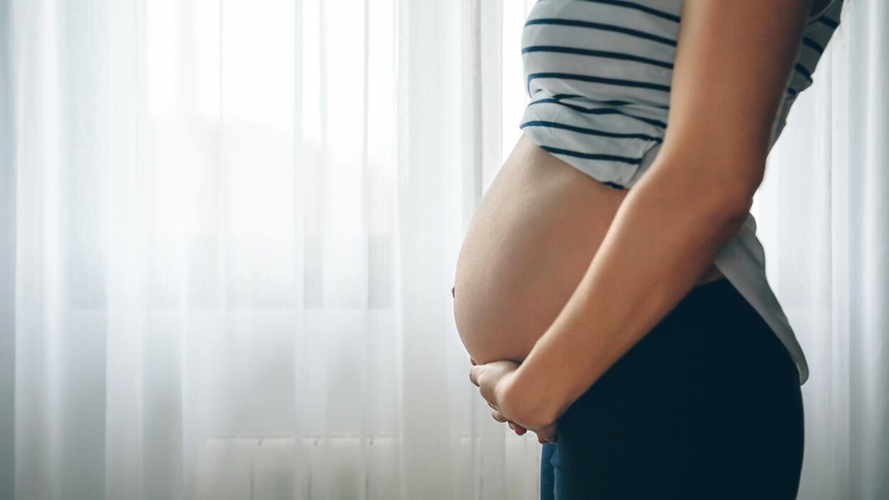 Une femme enceinte touche son ventre