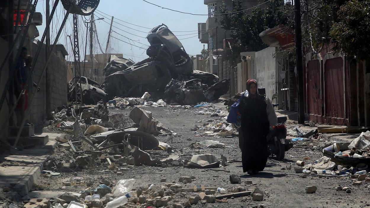 Une femme se promène dans les ruines de la ville de Mossoul, en Irak, où se poursuivent des combats entre les forces armées et les djihadistes du groupe armé État islamique. Une femme se promène dans les ruines de la ville de Mossoul, en Irak, où se poursuivent des combats entre les forces armées et les djihadistes du groupe armé État islamique.