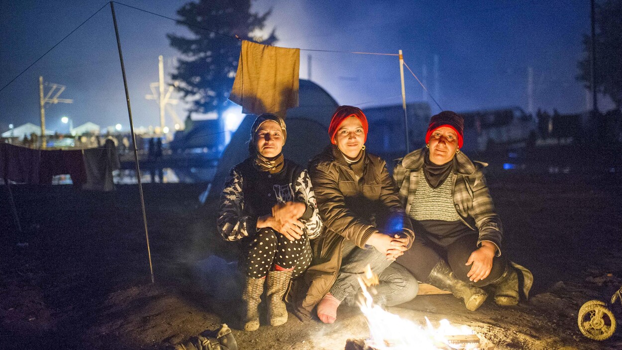 Des migrantes autour d'un feu de camp.
