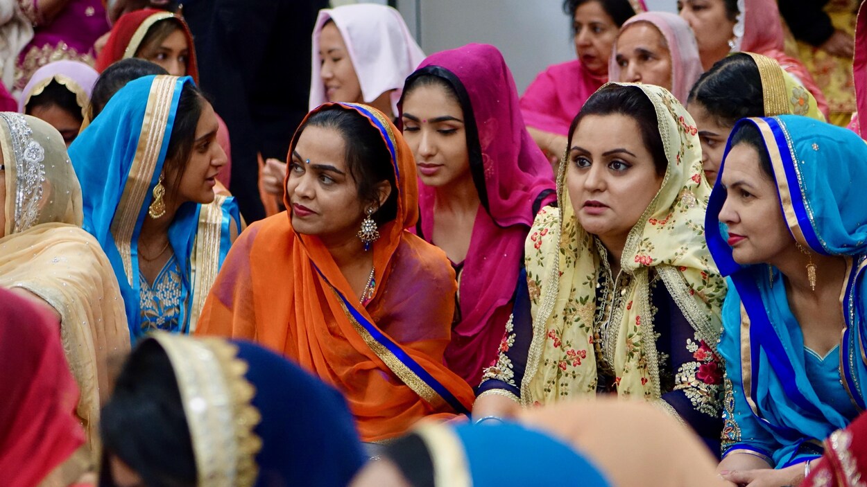 Des femmes qui portent des vêtements traditionnels participent à une cérémonie dans un temple sikh à Brampton, en Ontario.