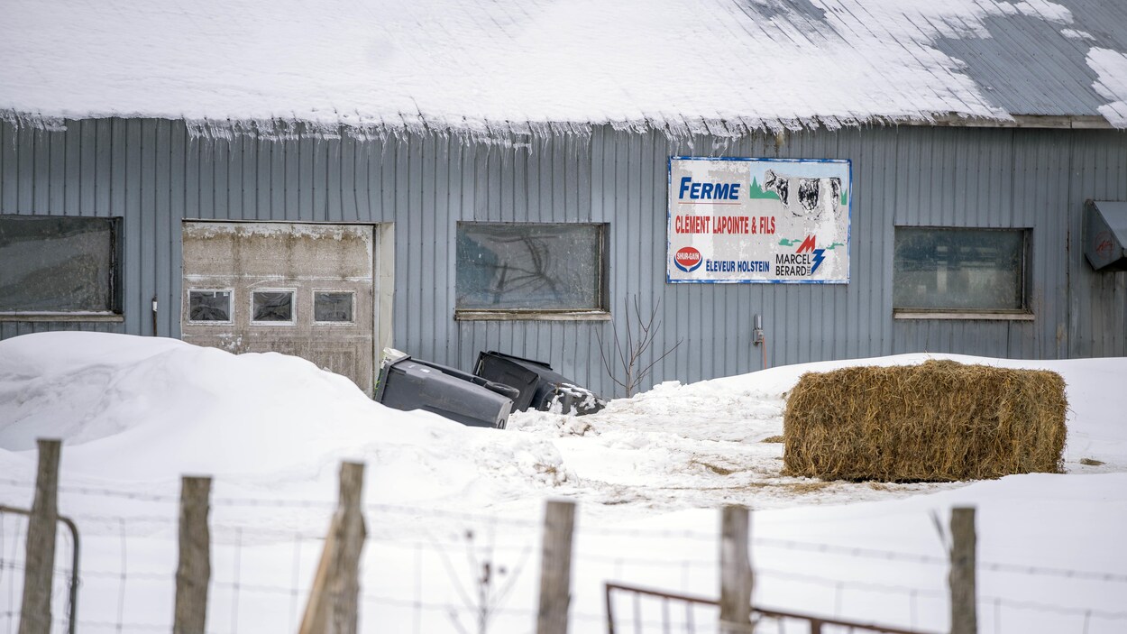 La devanture d'une grange, une botte de foin et une affiche de la fermer en hiver.