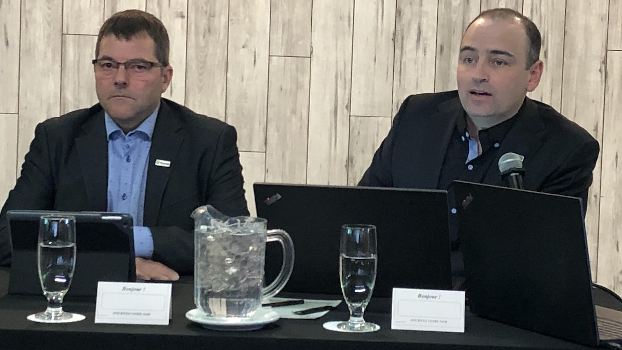 Jean-Nil Laganière et Dany Côté sont assis à une table de conférence de presse devant des ordinateurs portables.