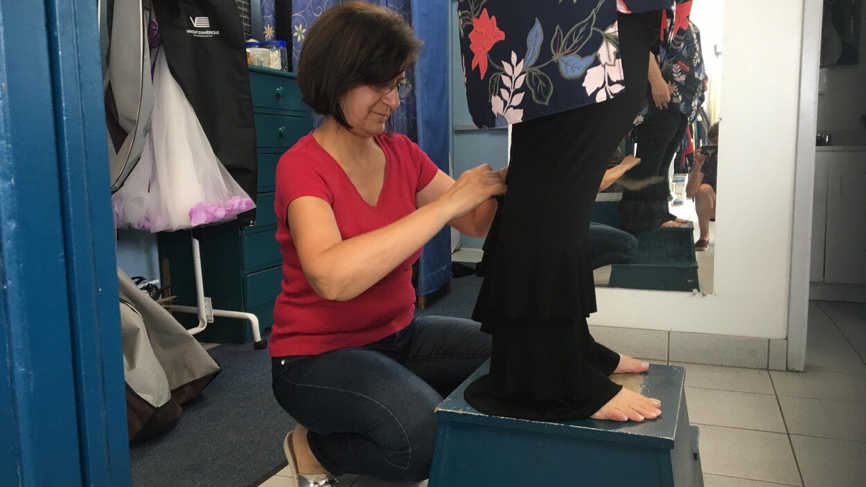 Une femme prend des mesures pour un bord de pantalon.