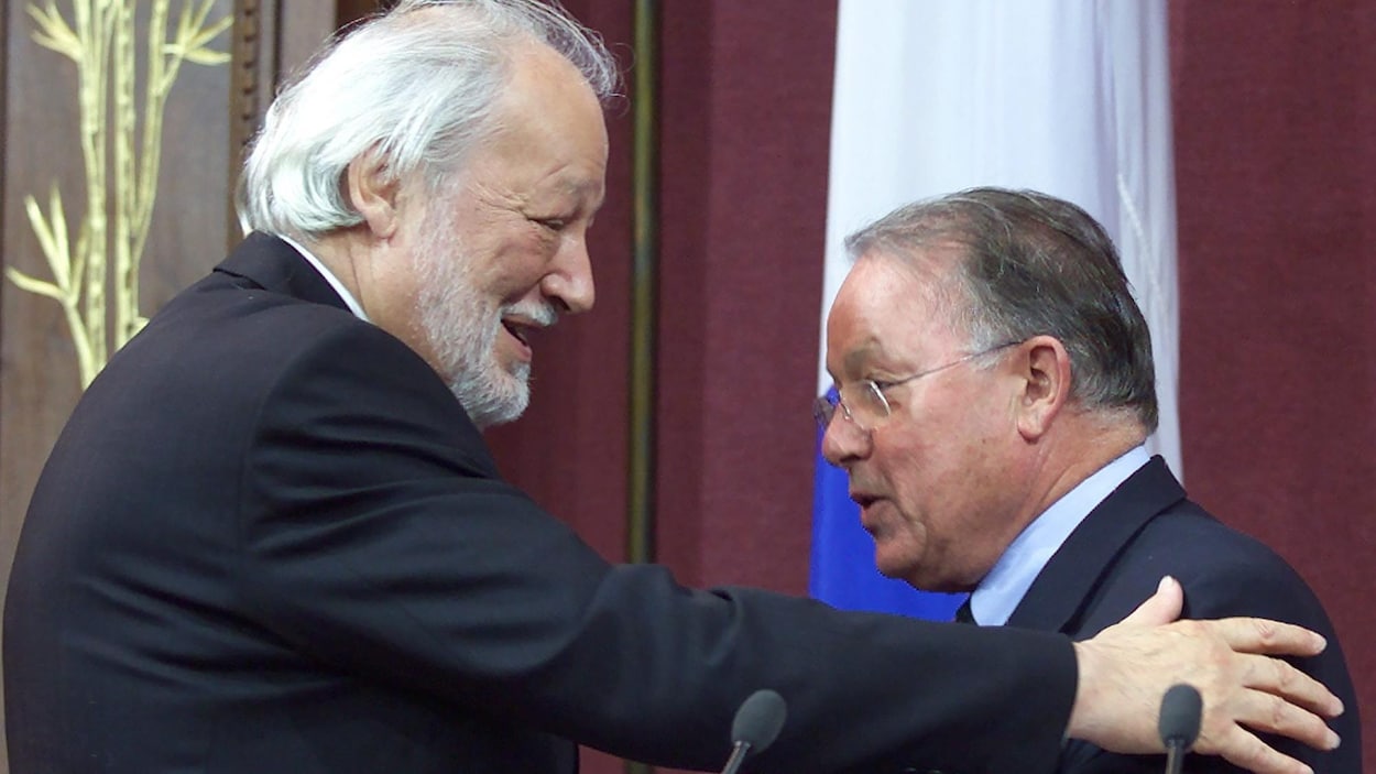 Les deux hommes se font une accolade.