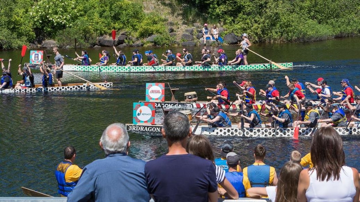 Des bateaux-dragons voguent sur une rivière.