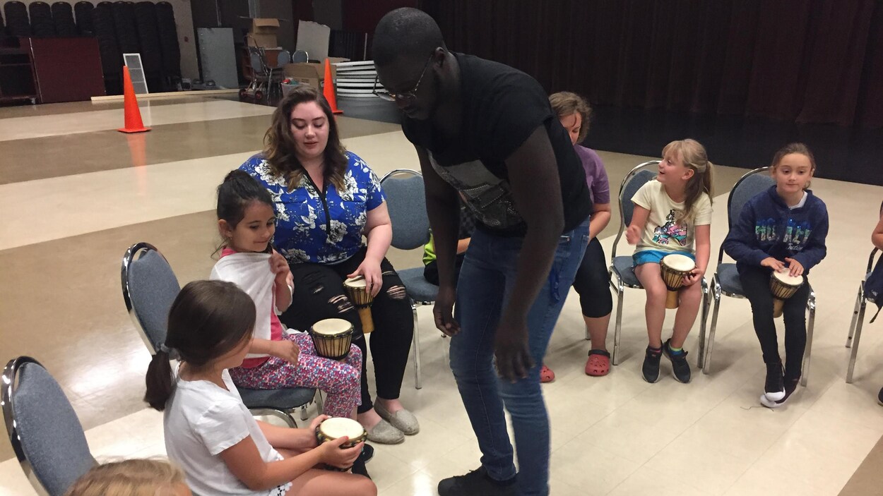 Des enfants apprennent à jouer du djembé.
