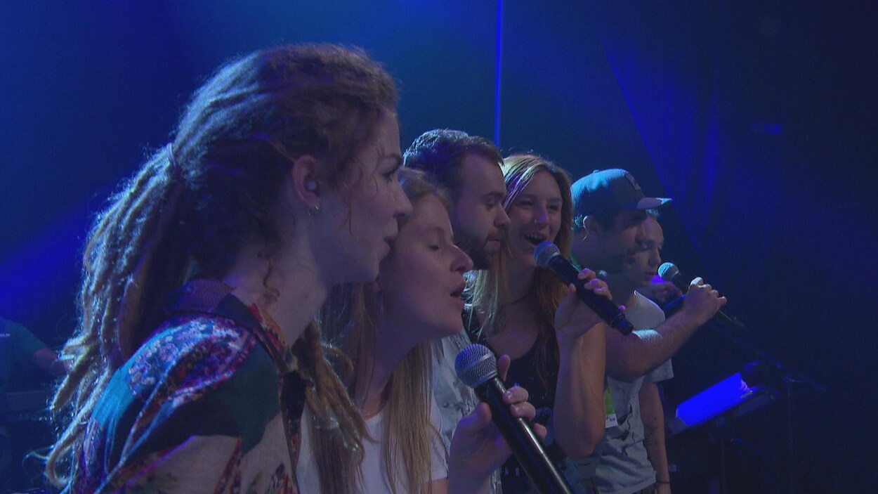 De jeunes chanteurs se pratiquent sur une scène.