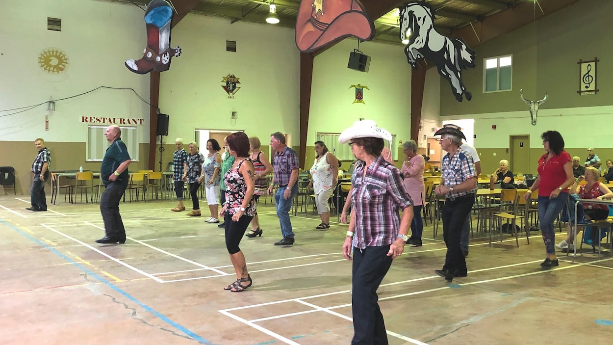 Des danseurs en ligne s'exercent dans un gymnase.