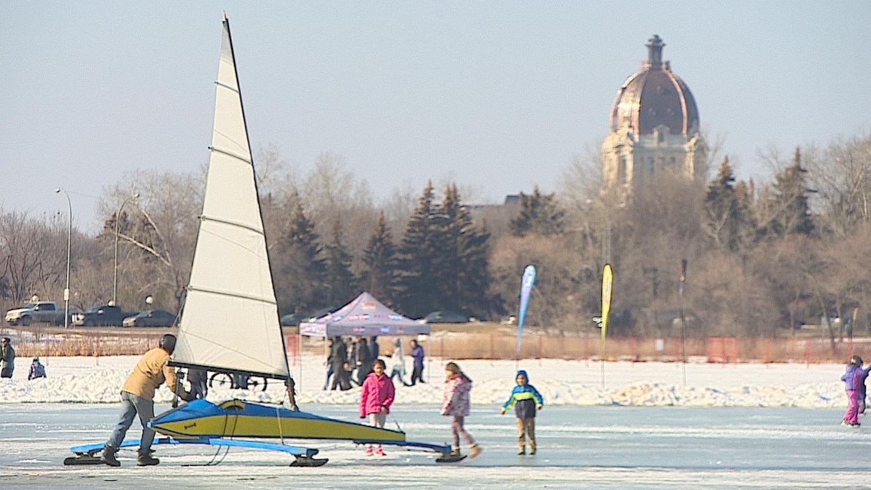 Des enfants jouent dehors dans le parc Waskana avec un voilier à glace.