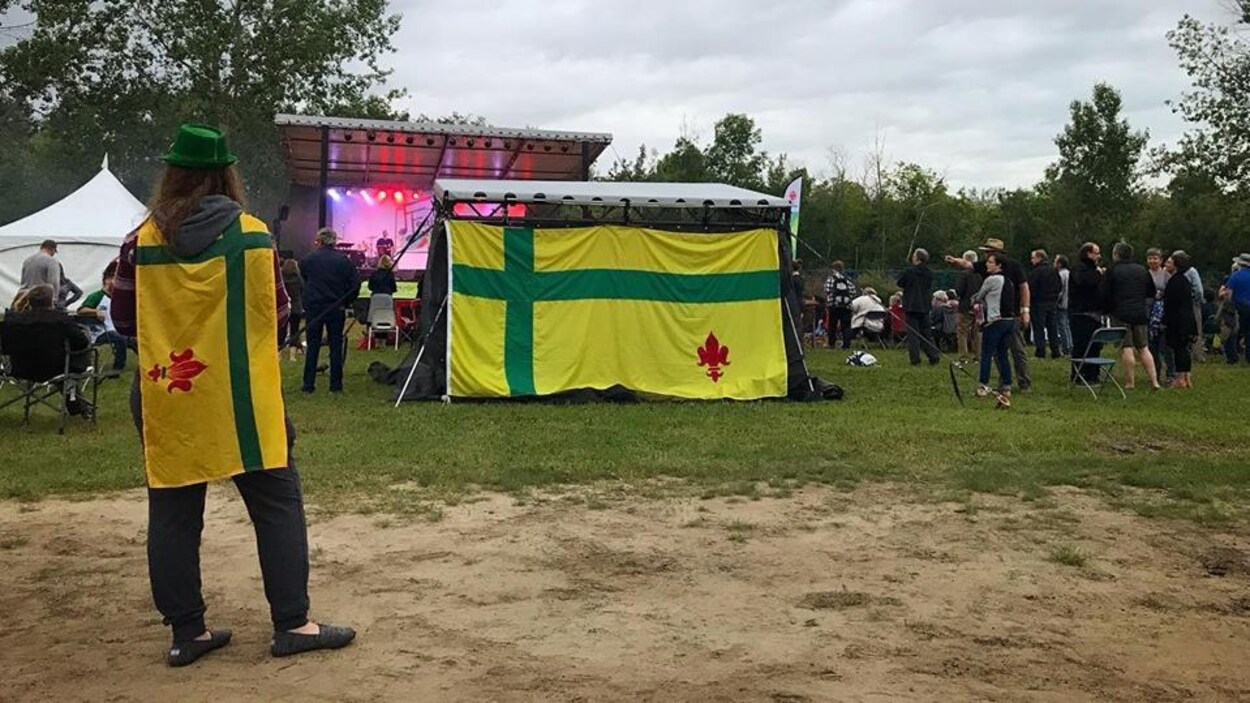 Un festivalier arborant le drapeau fransaskois sur le site du festival.