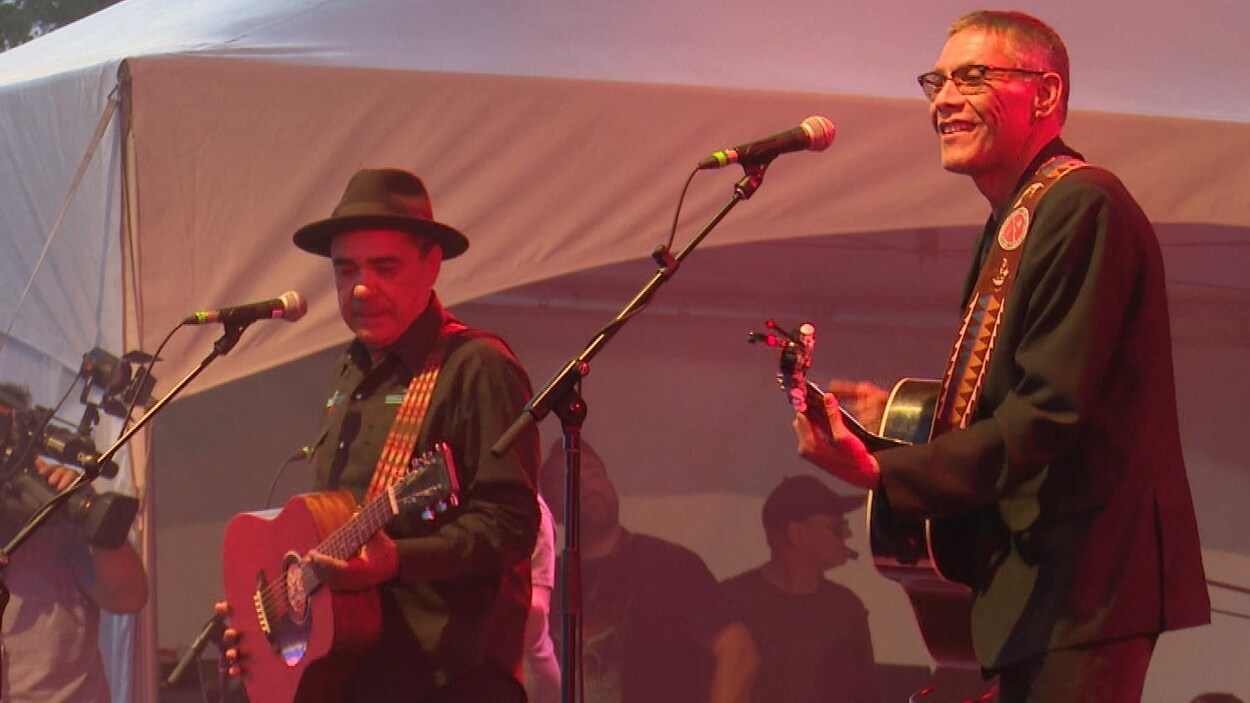 Florent Vollant porte un chapeau noir et Claude McKenzie est très souriant.