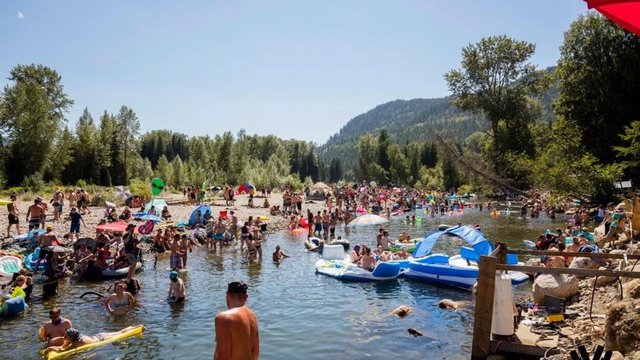 Des festivaliers du festival de musique électronique Shambhala se baignent dans l'eau