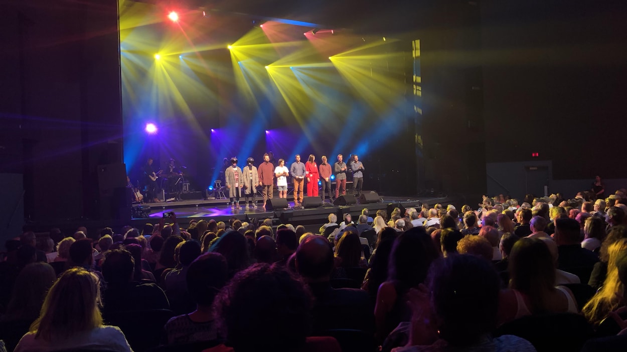 Les finalistes du 51e Festival international de la chanson de Granby, sur une scène extérieure devant une foule le soir.