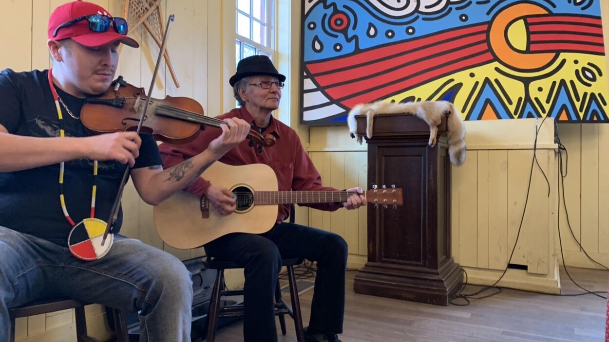 Deux musiciens, Blaine Constant Gerry McIvor, jouent de la guitare et du violon dans la maison du bourgeois située dans le fort Gibraltar à Saint-Boniface au Manitoba.