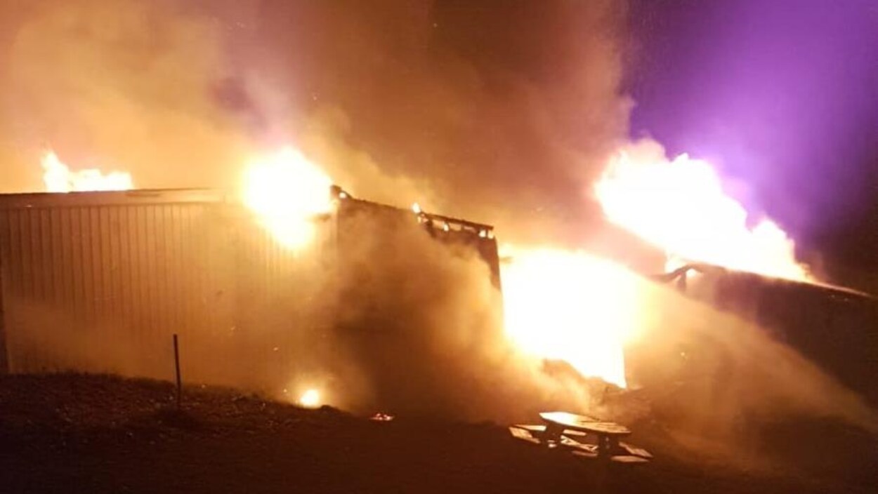 De grandes flammes sortent du toit de l'édifice