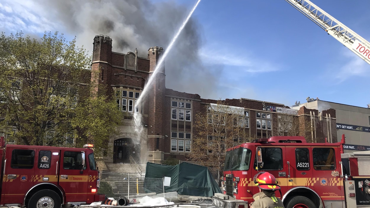 Des pompiers arrosent la façade d'un bâtiment