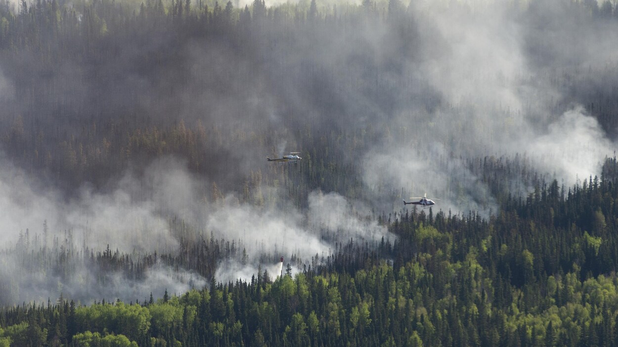 Un hélicoptère jette de l'eau sur les flammes à l'ouest de High Level.