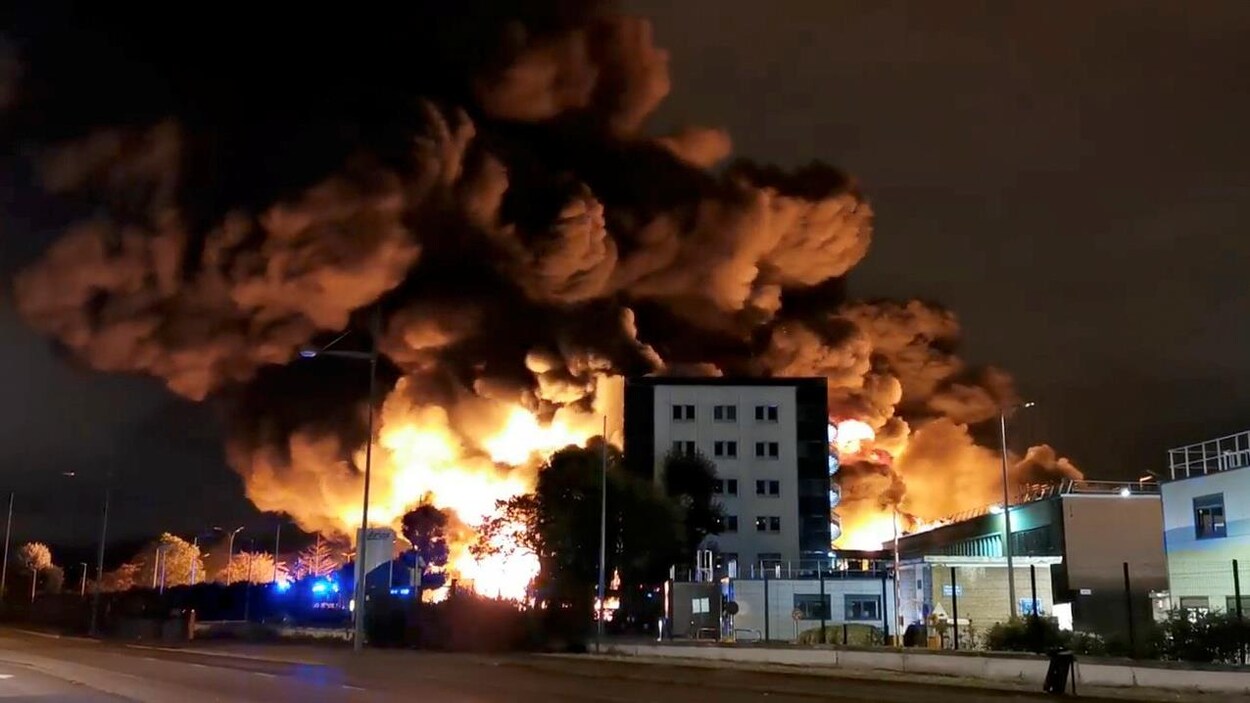 D'énormes flammes et de l'épaisse fumée émanent d'un édifice.