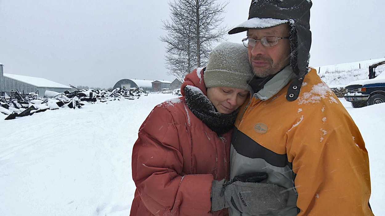 Le couple se serre dans ses bras près des ruines enneigées.