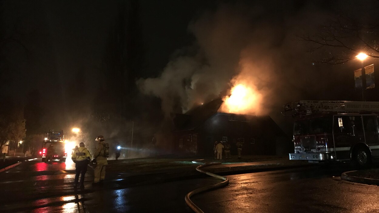 Des pompiers devant un immeuble en feu. Des pompiers devant un immeuble en feu.