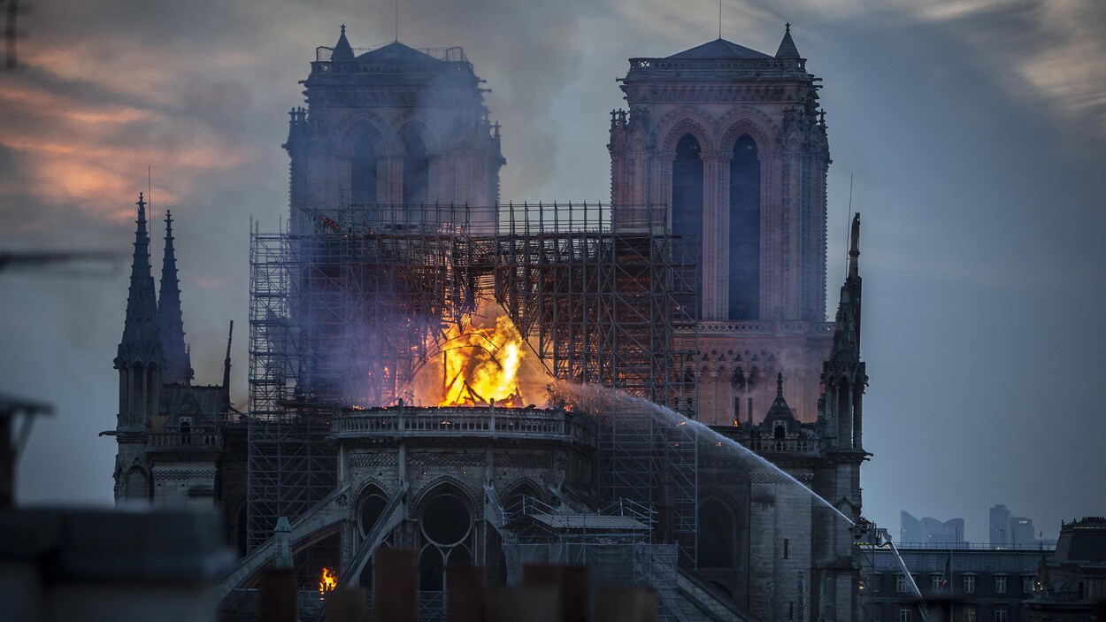 Les pompiers envoient d'immenses jets d'eau pour éteindre les flammes qui ravagent le centre de la cathédrale.