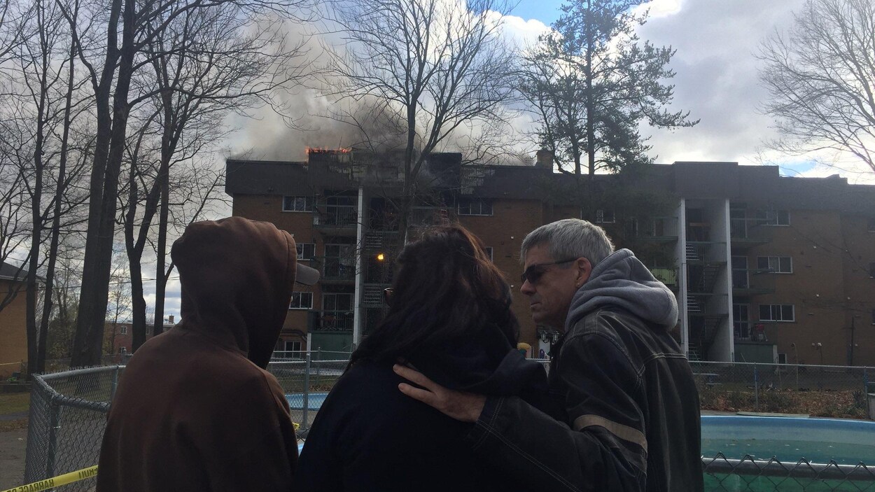 Des locataires évacués devant l'édifice en feu. Des locataires évacués devant l'édifice en feu.