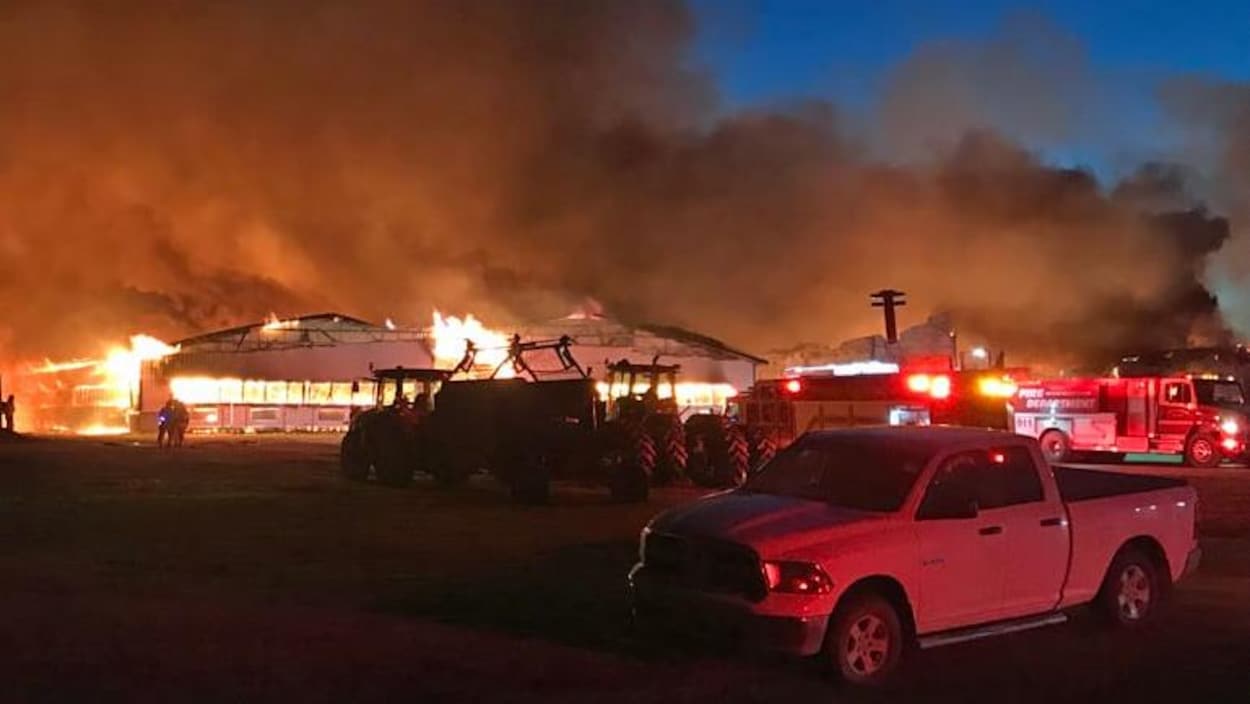 Le feu consume l'étable alors que les pompiers sont à l'œuvre.