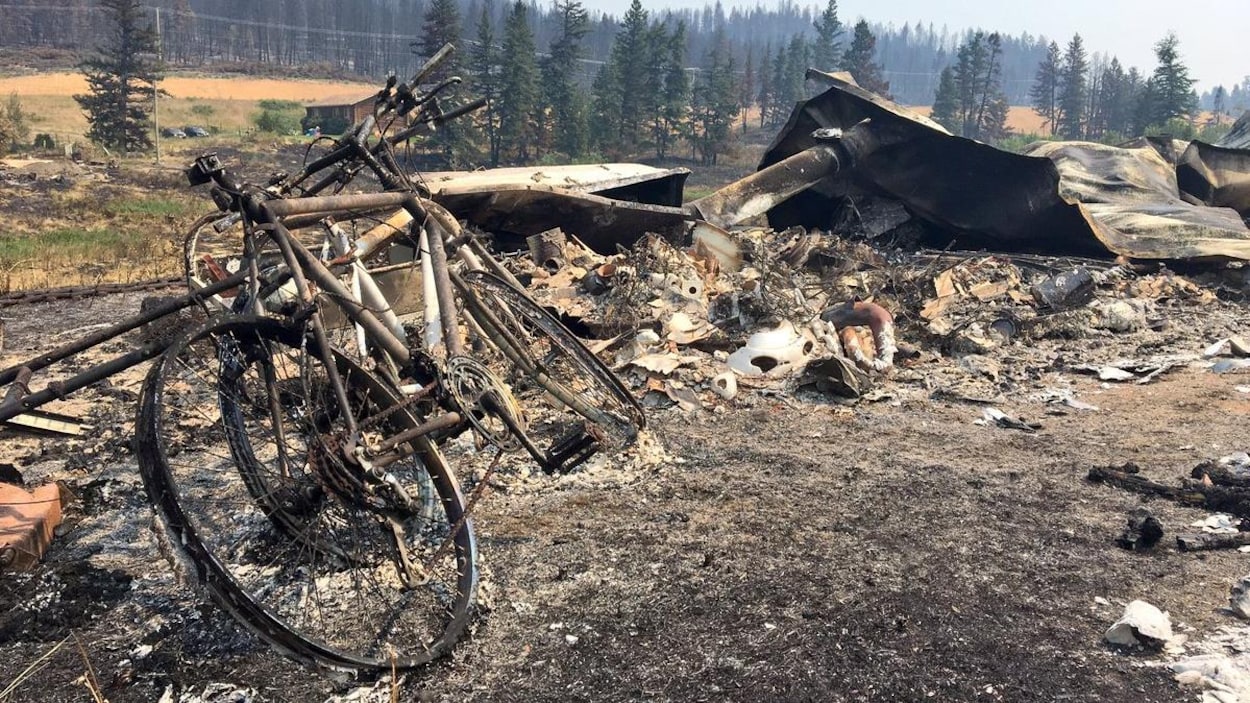 Une bicyclette et les restes d'une maison dans un secteur de la Colombie-Britannique dévasté par les feux de forêt Une bicyclette et les restes d'une maison dans un secteur de la Colombie-Britannique dévasté par les feux de forêt