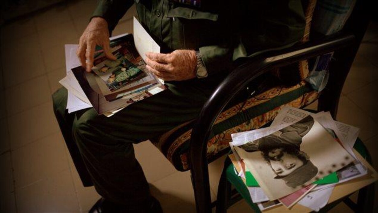 Personne assise consultant des photos et des souvenirs de Fidel Castro.