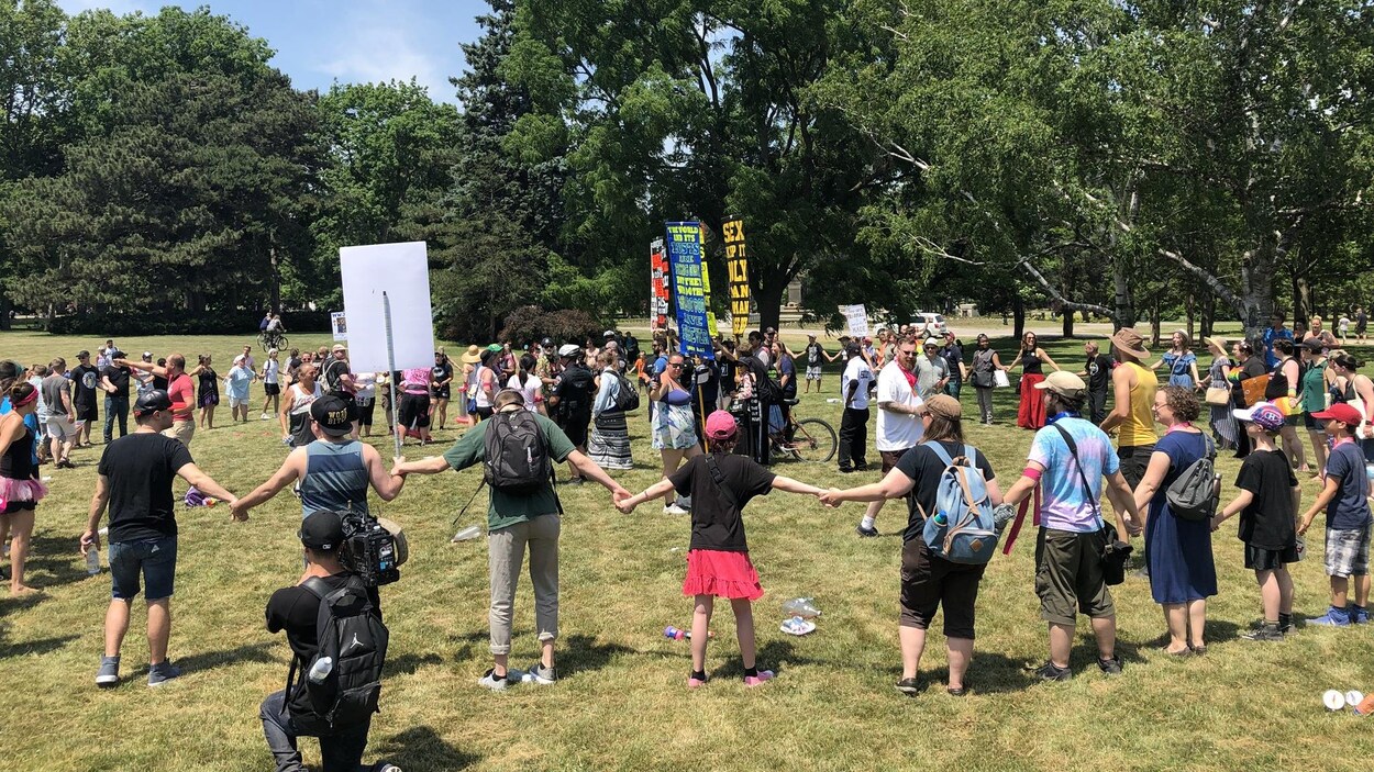 Les participants aux célébrations de la fierté gaie forment un cercle autour des manifestants anti-LGBT+.