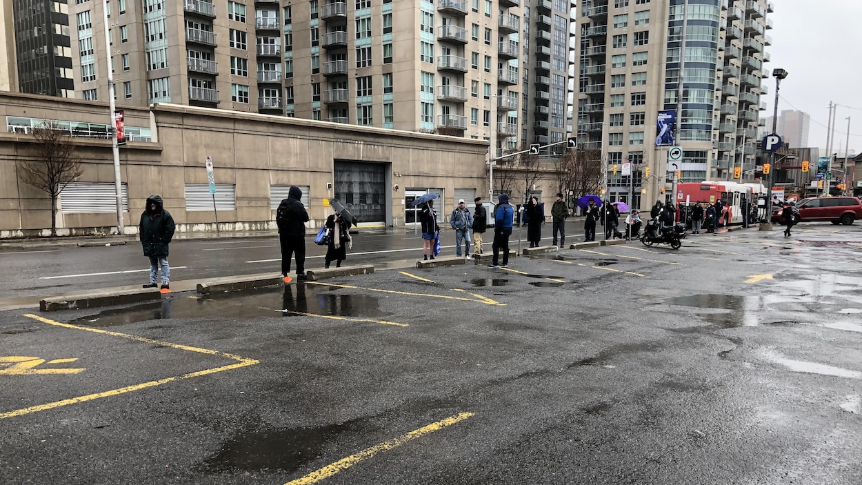 Une longue file de gens le long d'une rue d'Ottawa.