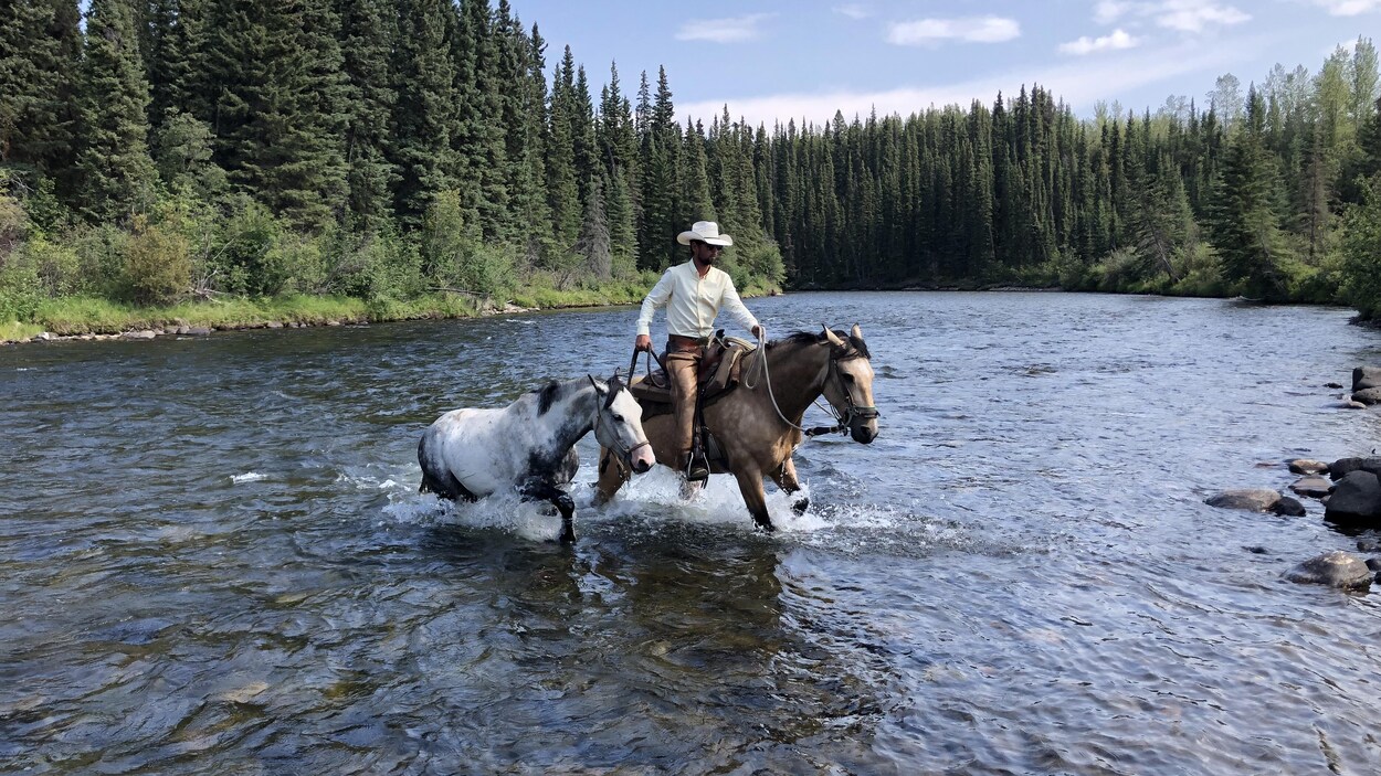 Filipe Masetti Leite traverse une rivière à cheval.