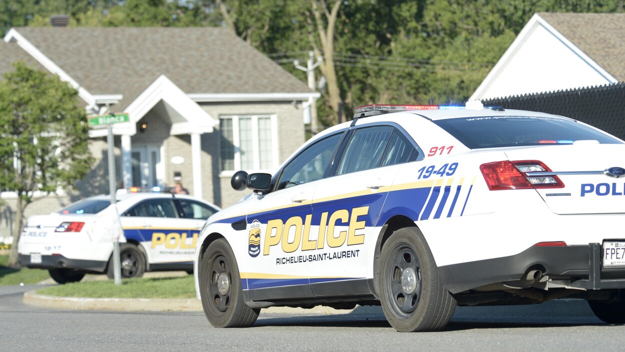 Des véhicules de police garés dans une rue résidentielle de Saint-Amable.