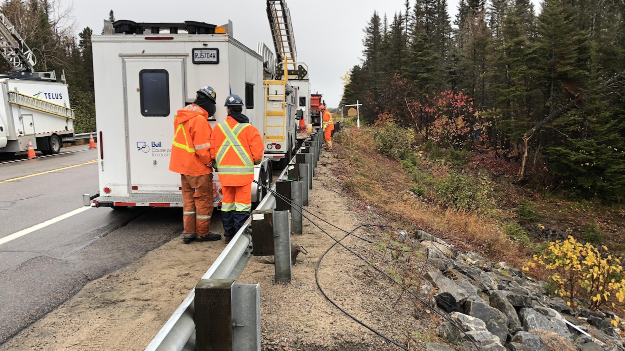 Des employés réparent des poteaux et des câbles près de Baie-Trinité.