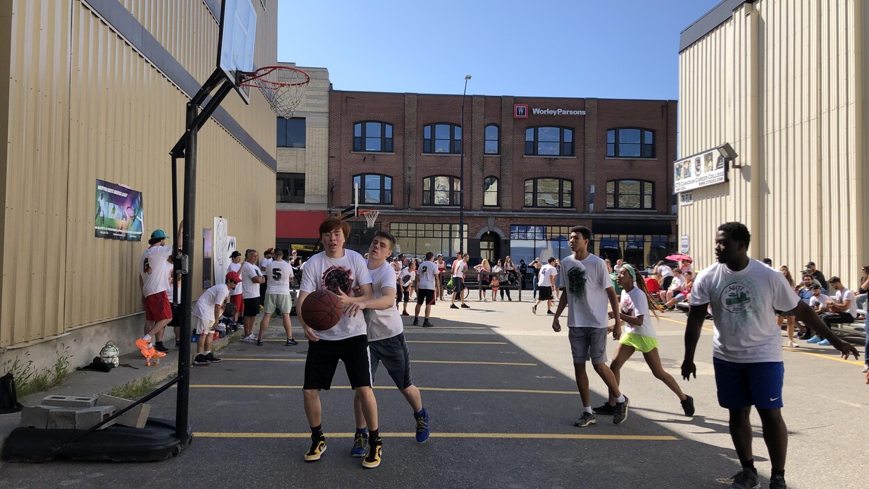 Des jeunes jouent au basketball à l'extérieur