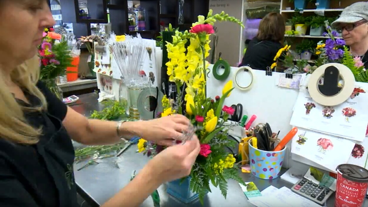 Une fleuriste travaille sur un bouquet de fleurs