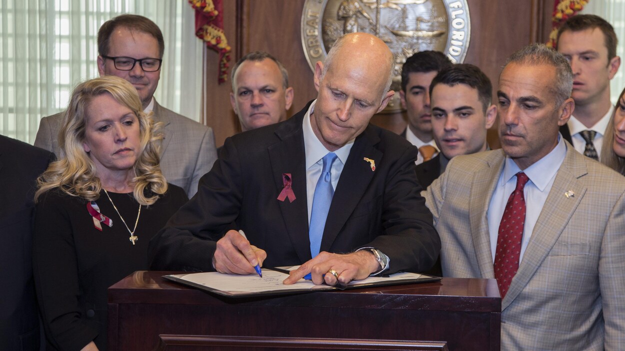 Le gouverneur de Floride, Rick Scott, signe la nouvelle loi « Marjory Stoneman Douglas Public Safety Act » en présence de parents de la tuerie de Parkland.