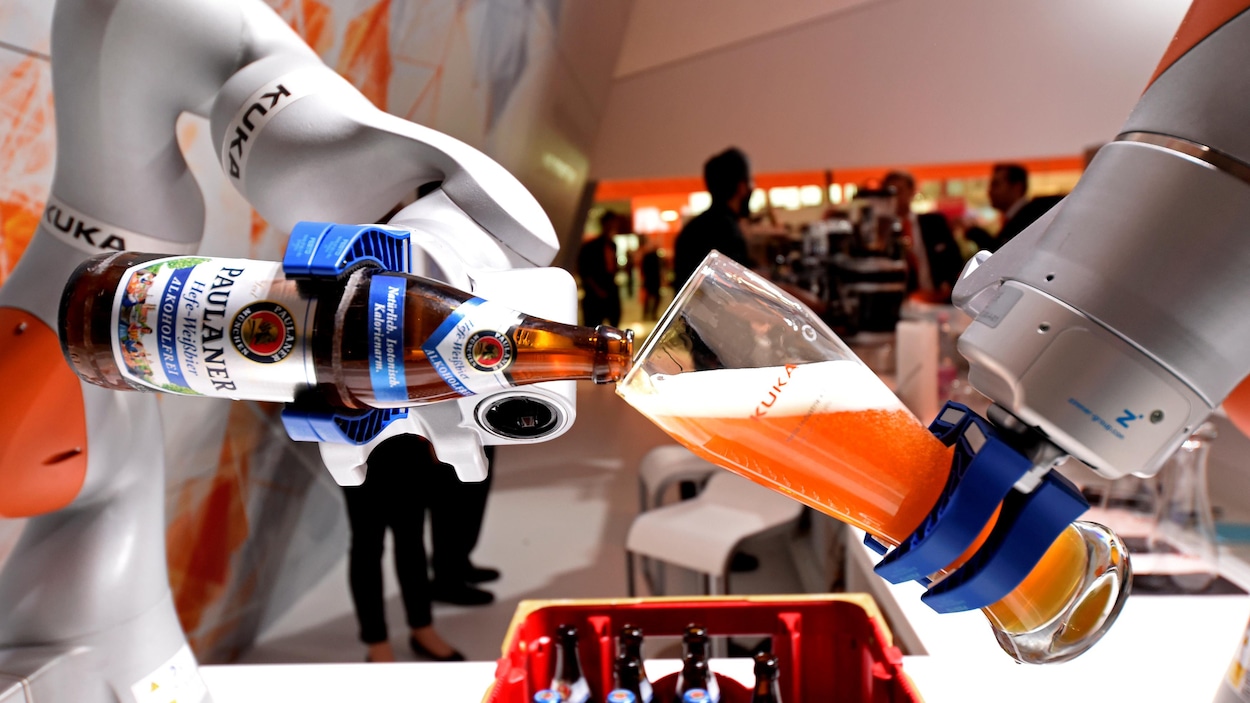 Un bras robotique verse de la bière dans un verre lors d'une présentation à la Foire de Hanovre, le plus grand salon de la technologie industrielle.