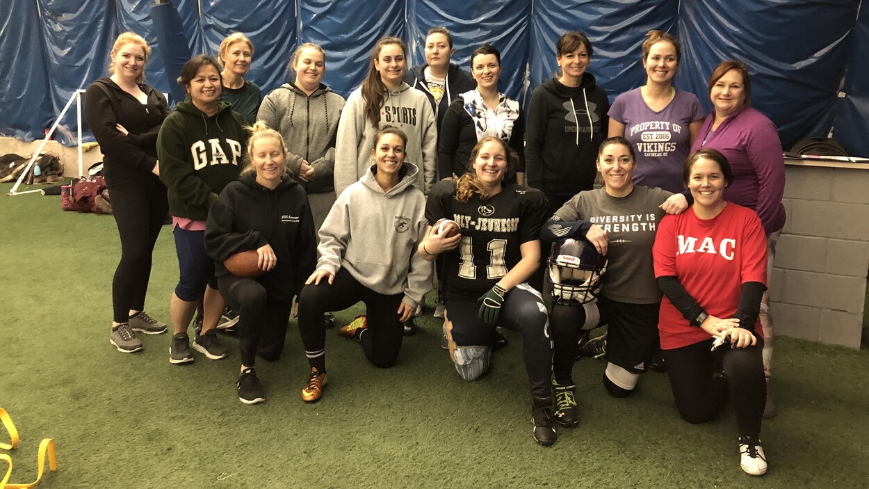 Un groupe de femmes prennent la pause sur un terrain de football.